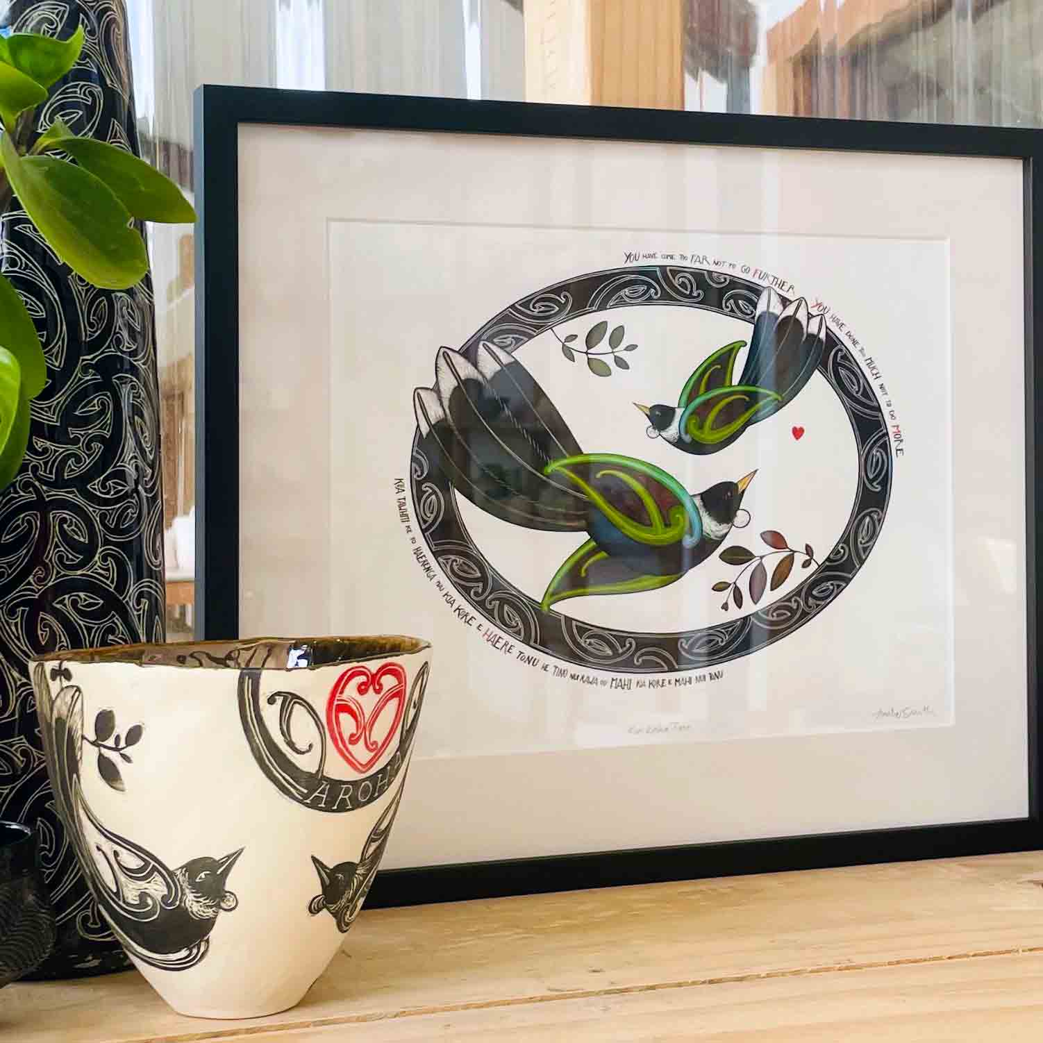 Framed Kia kaha Tui nz art print with maori art tui birds flying in a koru oval with an aroha love heart. Maori proverb in te reo maori and english Amber Smith New Zealand Aotearoa.