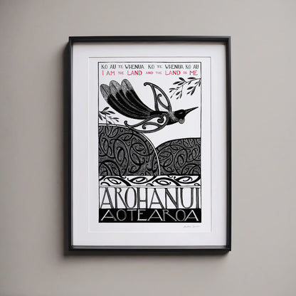 Framed New Zealand tūī art print, Ko au te Whenua – I Am the Land, featuring a tūī flying over the land and sea, with the te reo Māori whakataukī “Ko au te whenua, ko te whenua ko au” and its English translation, “I am the land and the land is me”.