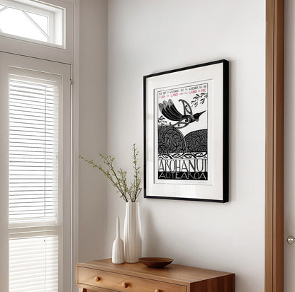 Framed New Zealand tūī art print, Ko au te Whenua – I Am the Land, featuring a tūī flying over the land and sea, with the te reo Māori whakataukī “Ko au te whenua, ko te whenua ko au” and its English translation, “I am the land and the land is me”.I am the land and the land is me te reo whakatauki art print with tui bird flying over koru pattern hils and sea