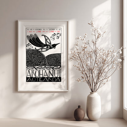 Framed New Zealand tūī art print, Ko au te Whenua – I Am the Land, featuring a tūī flying over the land and sea, with the te reo Māori whakataukī “Ko au te whenua, ko te whenua ko au” and its English translation, “I am the land and the land is me”.
