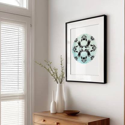 New Zealand bird art print, Manu Mandala by Amber Smith, featuring tūī and pīwakawaka flying together in a circular mandala against a hazy blue background, reflecting the beauty of Aotearoa’s native birds. Black frame in living room.