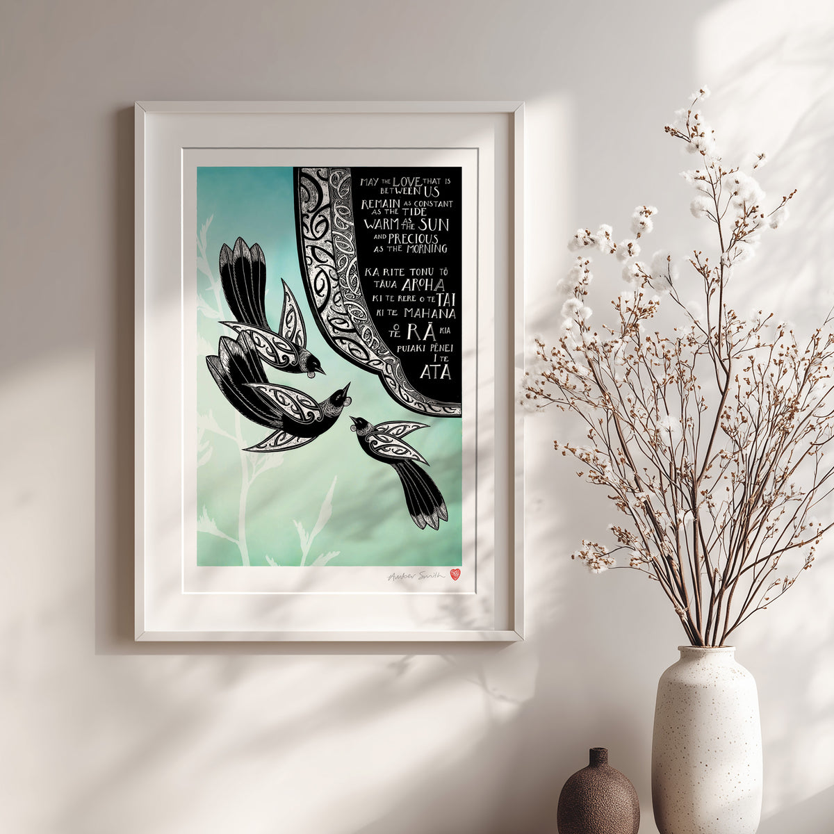 Framed Aotearoa tūī art print, May the Love That Is Between Us, featuring three tūī surrounded by kōwhaiwhai patterns, with a bilingual blessing in te reo Māori and English wishing that love remain constant as the tide, warm as the sun and precious as the morning.