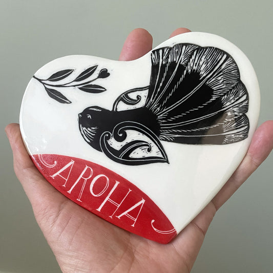 Ceramic wall heart with piwakawaka fantail and the word aroha