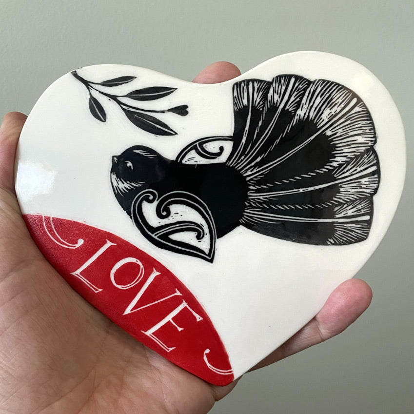 Ceramic wall heart with piwakawaka and the word Love