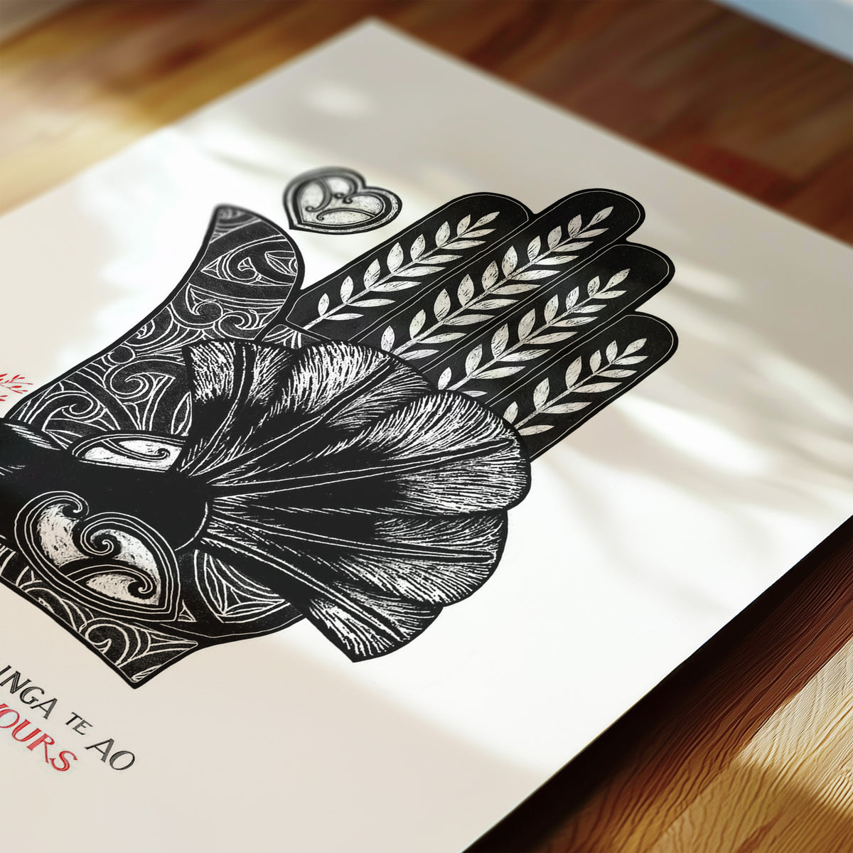Detail of New Zealand pīwakawaka art print, The World Is Yours – Kei ōu ringaringa te ao, featuring a fantail resting in the palm of a hand surrounded by flowing kōwhaiwhai patterns, with a message of confidence, protection and new beginnings.