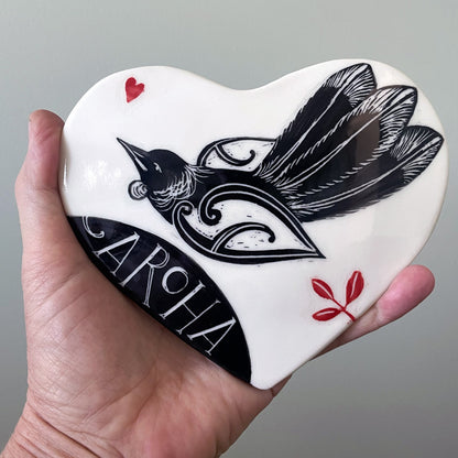Ceramic wall heart with tui bird and the word aroha