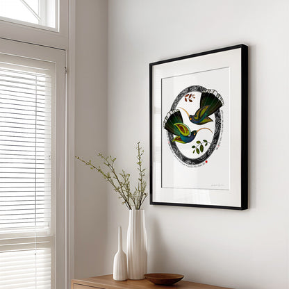 New Zealand huia bird art print, Tūmanako – Hope, featuring two huia taking flight into the light of a new dawn, with a te reo Māori karakia about the birds calling and the day beginning. Shown in living room with black frame.